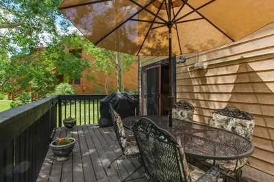 a patio with a table and chairs and an umbrella at Meadow Creek in Frisco