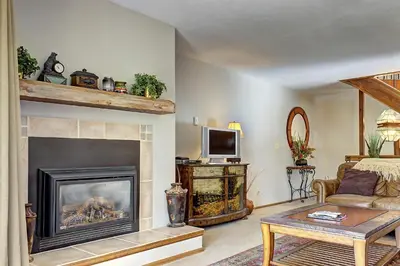 a living room with a fireplace and a couch at Divide View Townhome in Winter Park