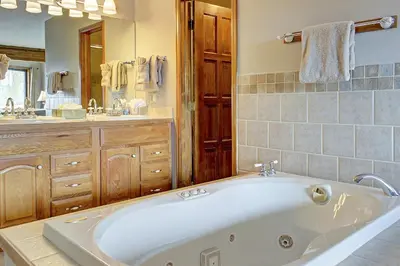 a large white tub in a bathroom with a mirror at Divide View Townhome in Winter Park