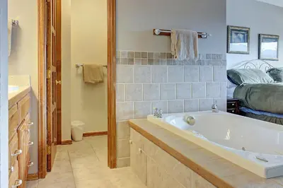 a bathroom with a tub and a bedroom with a bed at Divide View Townhome in Winter Park