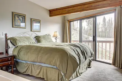 a bedroom with a bed and a large window at Divide View Townhome in Winter Park