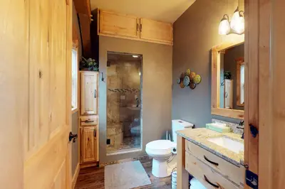 a bathroom with a toilet and a sink and a shower at Fraser Cabin in the Woods in Fraser