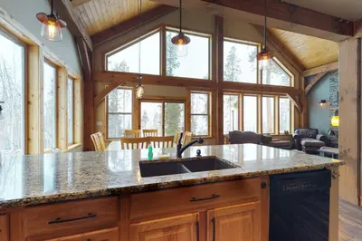 a kitchen with a sink and a bunch of windows at Fraser Cabin in the Woods in Fraser