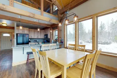 a kitchen and dining room with a wooden table and chairs at Fraser Cabin in the Woods in Fraser