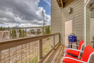 a balcony with red chairs and a view of the water at Wildernest Gore Trail Condo in Silverthorne