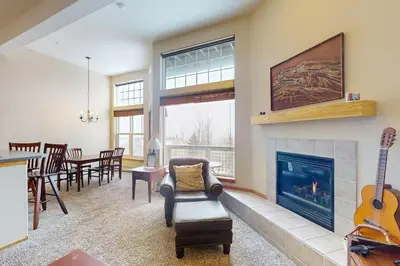 a living room with a fireplace and a dining room at Wildernest Gore Trail Condo in Silverthorne