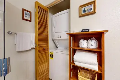 a small laundry room with a washer and dryer at Wildernest Gore Trail Condo in Silverthorne