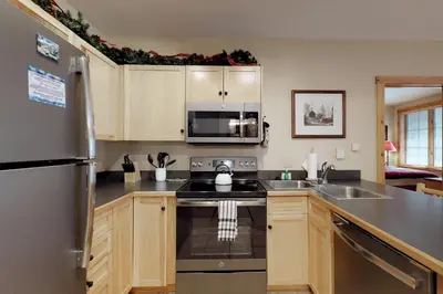 a kitchen with a sink and a refrigerator at The Dakota Outpost in Keystone