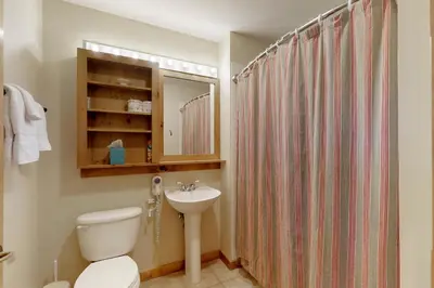 a bathroom with a toilet and a sink and a shower at The Dakota Outpost in Keystone