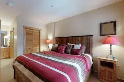 a bedroom with a large bed and two lamps at The Dakota Outpost in Keystone