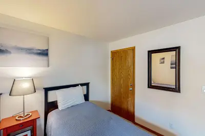 a bedroom with a bed and a lamp and a mirror at Buffalo Village Condo & Treetop Hideaway in Silverthorne