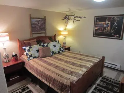 a bedroom with a large bed with two lamps at Kokopelli Inn in Estes Park