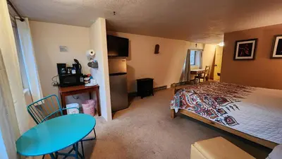 a bedroom with a bed and a table and a table and chairs at Kokopelli Inn in Estes Park