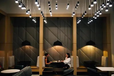 two people sitting at a table in a restaurant at AC Hotel by Marriott Denver Downtown in Denver