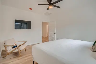 a white bedroom with a bed and a chair at Uplift Inn in Idaho Springs