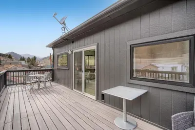 a wooden deck with a bench on a house at Uplift Inn in Idaho Springs