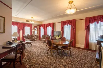 a living room with red curtains and a table and chairs at Hotel Boulderado in Boulder