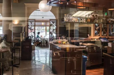 a restaurant with a bar with a person in the background at Hotel Boulderado in Boulder