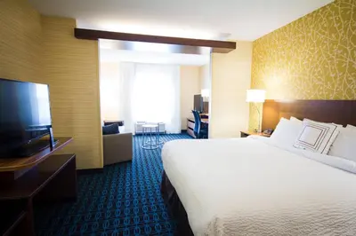 a hotel room with a bed and a flat screen tv at Fairfield Inn & Suites by Marriott Denver Northeast/Brighton in Brighton