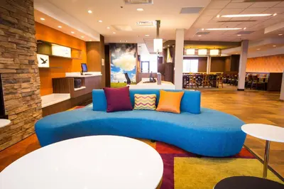 a blue couch with colorful pillows in a lobby at Fairfield Inn & Suites by Marriott Denver Northeast/Brighton in Brighton