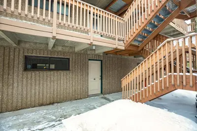 a wooden staircase in a building with snow on the ground at Ten Mile Creek Condo: Downtown Frisco, Hot Tub in Frisco