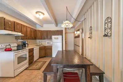 a kitchen with white appliances and a wooden table at Ten Mile Creek Condo: Downtown Frisco, Hot Tub in Frisco