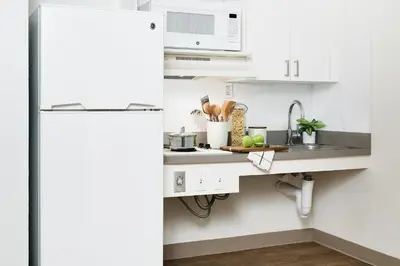 a kitchen with a sink and a white refrigerator at InTown Suites Extended Stay Denver - Havana Street in Aurora