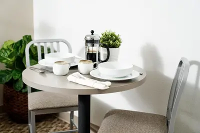 a table with plates and cups and a coffee maker on it at InTown Suites Extended Stay Denver - Havana Street in Aurora