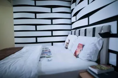 a bedroom with a white bed with a black and white wall at Airport Lay Over in Denver