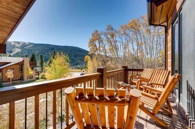 a balcony with two chairs and a view of the mountains at Sanctuary 2569 in Keystone