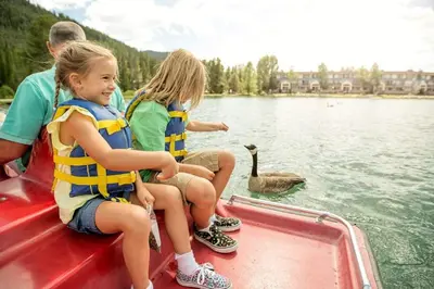 two girls and a man on a boat with a swan at Sanctuary 2569 in Keystone