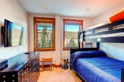 a bedroom with a bed and a desk and a bunk bed at Timbers 3077 in Keystone