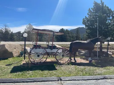 a horse is standing next to a carriage at Saddle & Surrey Motel in Estes Park