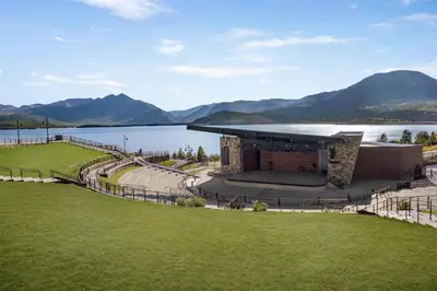 a building next to a body of water with mountains at Hyatt Place Keystone - Dillon in Keystone
