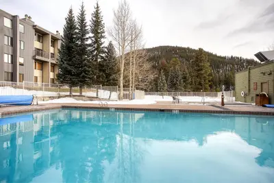 a swimming pool with blue water in front of a building at Keystone Lodge & Spa, A Vail Resorts Property in Keystone