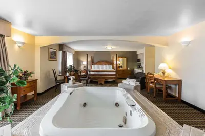 a large bath tub in a room with a bedroom at Quality Inn and Suites Silverthorne - Copper Mountain in Silverthorne