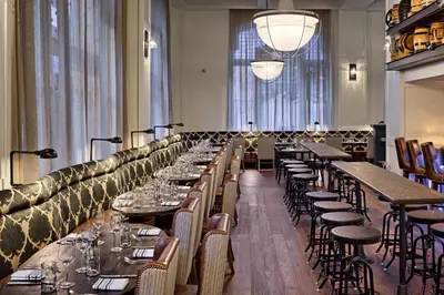 a row of tables and chairs in a restaurant at Hotel Teatro in Denver