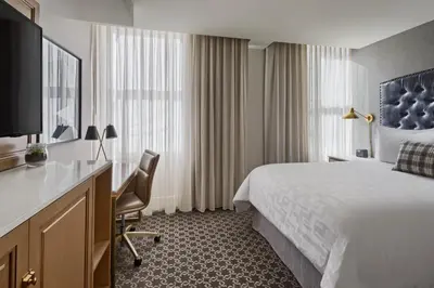 a hotel room with a bed and a desk at Hotel Teatro in Denver