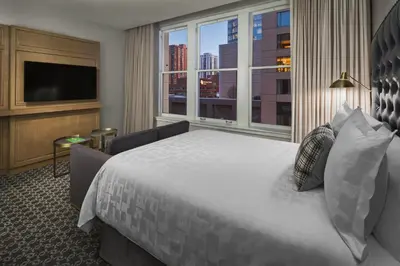 a hotel room with a large bed and a large window at Hotel Teatro in Denver