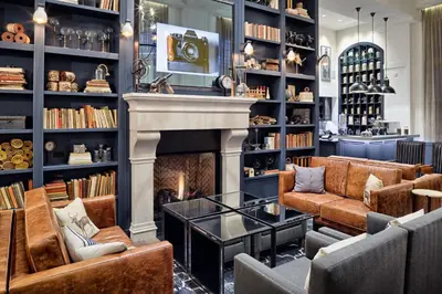 a fireplace in a library with couches and a fire place at Hotel Teatro in Denver