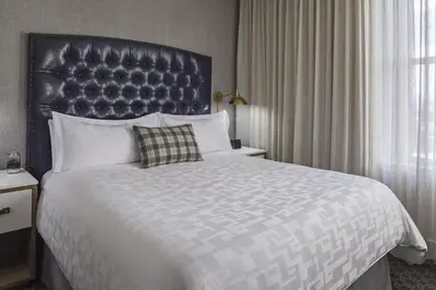 a bedroom with a large bed with a large headboard at Hotel Teatro in Denver