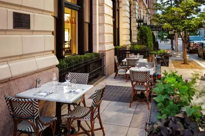 a restaurant with tables and chairs on a sidewalk at Hotel Teatro in Denver