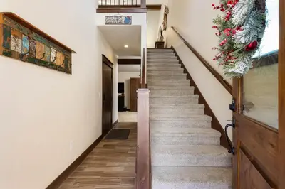 a staircase with a christmas wreath on the wall at 47B River Run Townhomes in Keystone