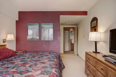 a bedroom with a bed and a red wall at 2092 The Pines Condo in Keystone