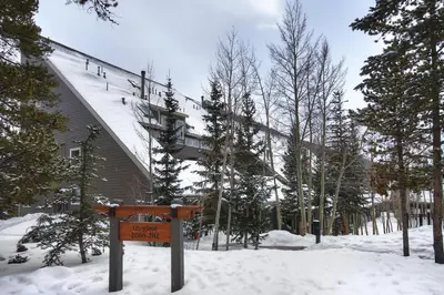 a sign in the snow in front of a building at 2092 The Pines Condo in Keystone