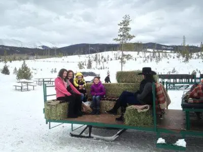 a group of people sitting on a bus in the snow at Silverado II in Winter Park