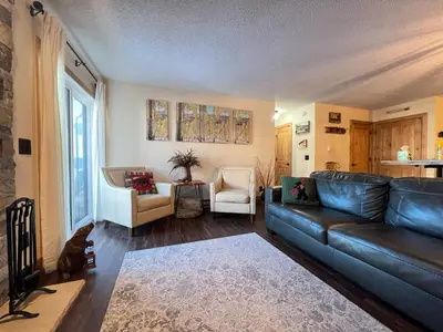 a living room with a leather couch and a kitchen at Silverado II in Winter Park