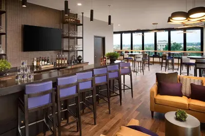 a restaurant with a bar with blue stools at Doubletree By Hilton Greeley At Lincoln Park in Greeley