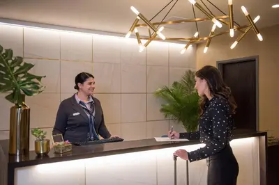 two people standing at a counter in a room at Magnolia Hotel Denver, a Tribute Portfolio Hotel in Denver