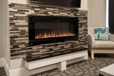 a fireplace in a living room with a brick wall at Magnolia Hotel Denver, a Tribute Portfolio Hotel in Denver